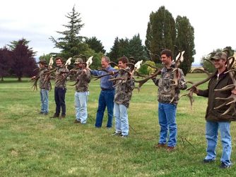 Discover the bond between hunters and nature at Red Stag Patagonia, as men pose with a remarkable deer antler, commemorating their unforgettable experience